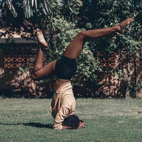woman in an upside down yoga position with her legs above her head